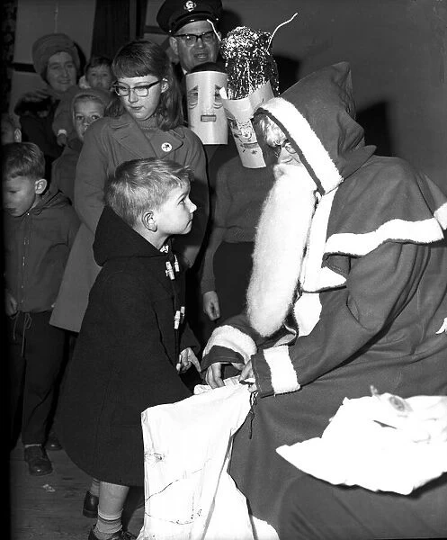 Santa Claus gives a little boy a present at St. John Ambulance bazaar, Holyhead Road