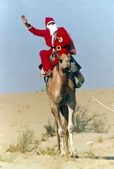 Framed Print : Santa Claus waves from atop his camel in the desert on his way to delivering a message to Framed Print : Santa Claus waves from atop his camel in the desert on his way to delivering a message to