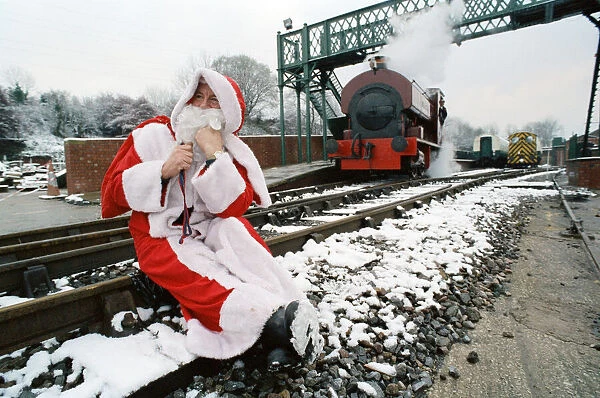 Santa stopped in his tracks. Father Christmas sitting on railway tracks
