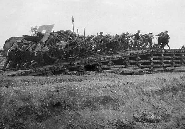 Sappers and gunners pull a artillery piece up the slope over the previously laid railway