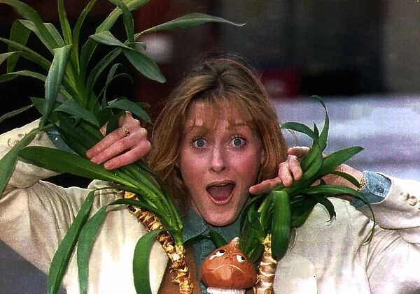 Sarah Lancashire actress poking her head through a plant