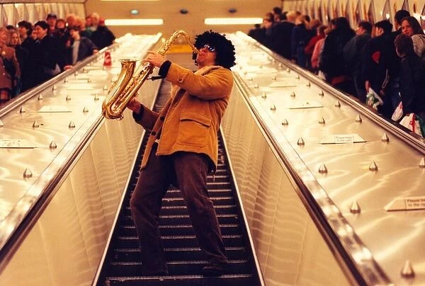 Sax player Jason Tenniswood in a wig entertains travellers at Monument Metro station