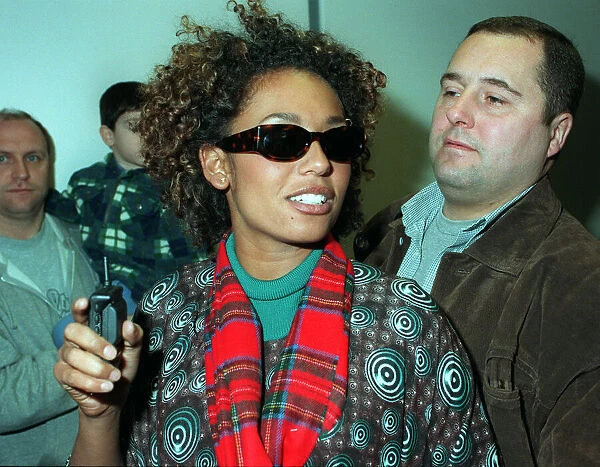 SCARY SPICE AT AIRPORT APRIL 1998 Spice Girls Mel B wearing a tartan scarf