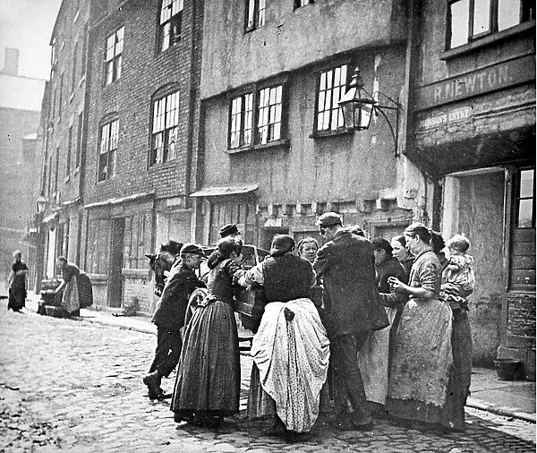 A scene of working class life - women gather round the horse-drawn cart of a street