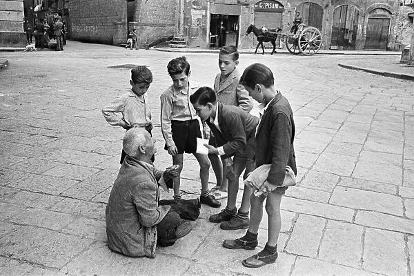 Scenes in Naples, southern Italy showing young boys talk to a beggar in the city streets