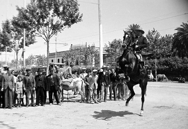 Scenes of Seville Man on horse making it rear up as the crowd watches