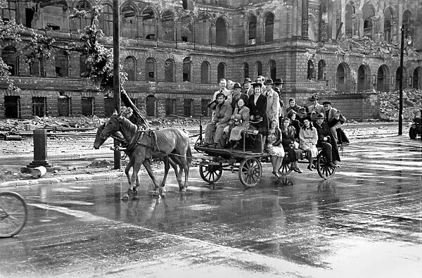 Scenes showing children being pulled along on a horse-drawn cart in the devastated German