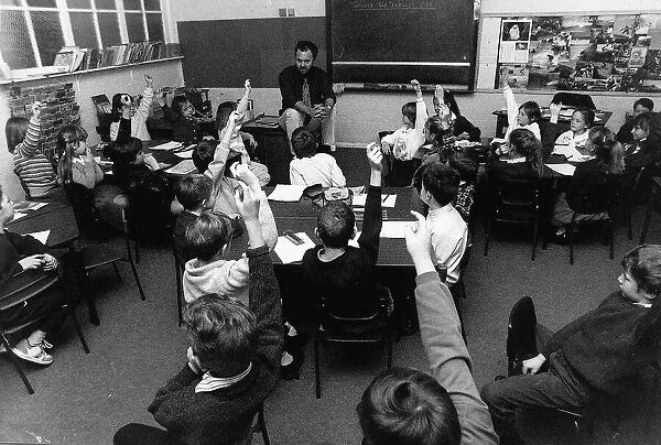 School Children with their hands up in class. Seen here during a history lesson. 1990