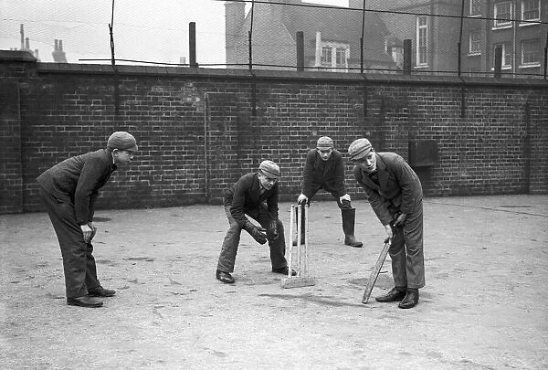 Schoolboys playing cricket in the school yard. Circa 1945