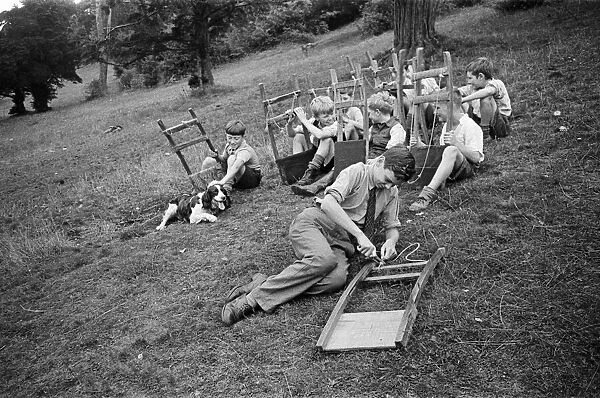 Schoolboys from West Wycombe go tobogganing on a hill in the village. circa 1945