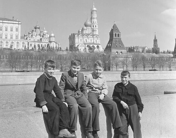Four schoolchildren pose on the banks of the Moskva River in Moscow
