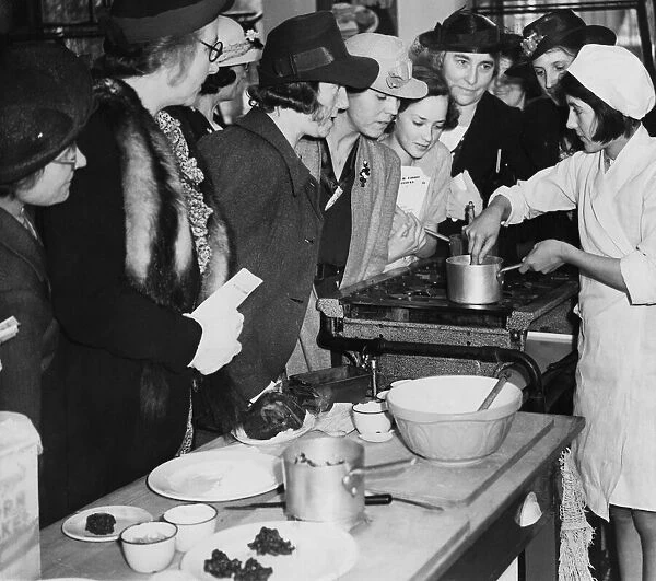Schoolgirls demonstrating cooking to their mothers at Orange Hill School in Burnt Oak