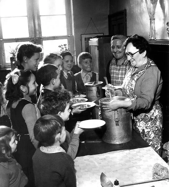 Schoolmistress Jean Cambell serving 17 children their school dinner