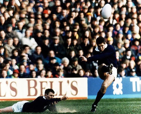 Scotland rugby skipper Gavin Hastings kicking ball in air which was held in place by