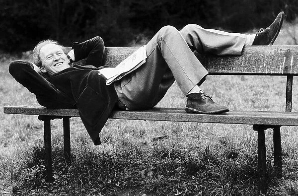Scottish actor Gordon Jackson relaxing on park bench 1975 on Hampstead Heath