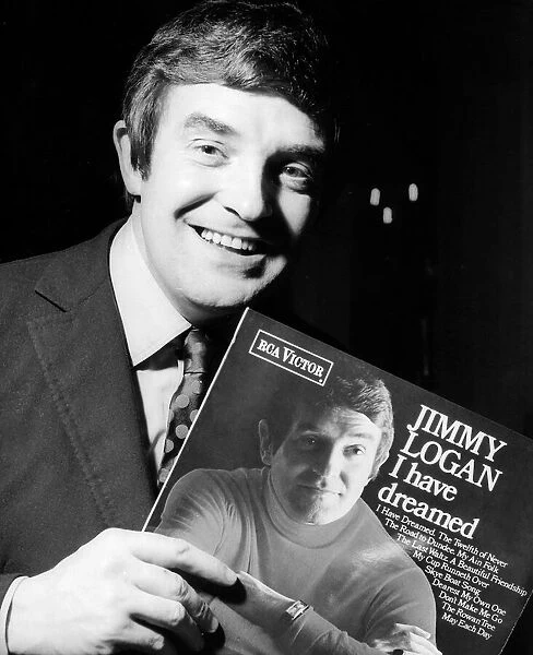 Scottish comedian Jimmy Logan holding a copy of his record 'I Have Dreamed'