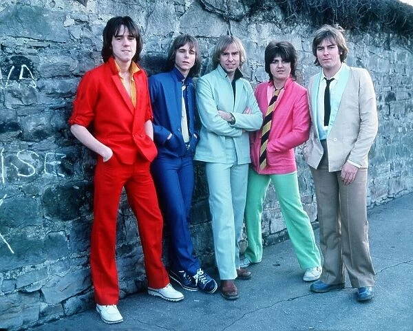 Scottish pop group The Bay City Rollers, standing against a wall wearing light coloured