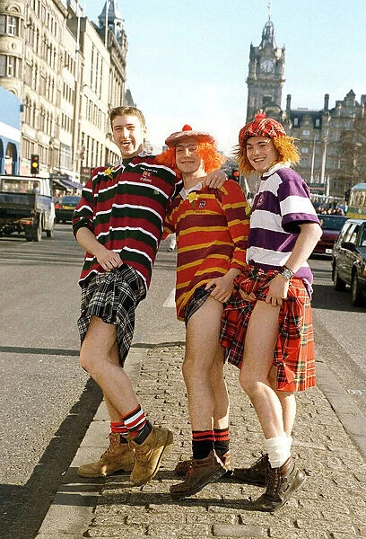 Scottish rugby fans wearing tartan kilts showing a leg on Princes Street Edinburgh prior