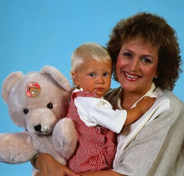 Scottish singer and actress Barbara Dickson holding her son and a teddy bear