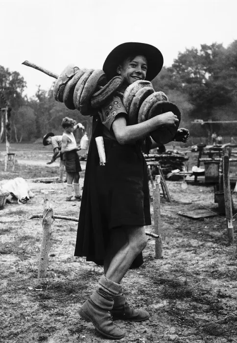 Framed Print : A scout is carrying holed bread with a pole through the centre of them on his shoulder