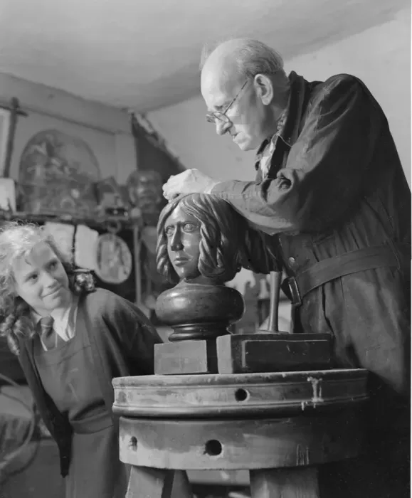 Framed Print : Sculptor William Snell seen here at work in his studio being watch by his schoolgirl Framed Print : Sculptor William Snell seen here at work in his studio being watch by his schoolgirl