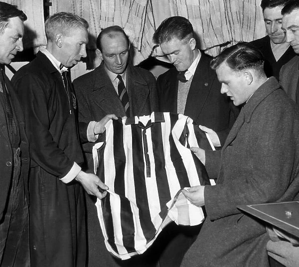 Scunthorpe United players & coaching staff examine shirt of local works team that they