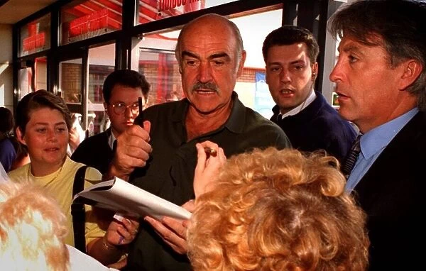 Sean Connery with moustache and mouth open holding a pen