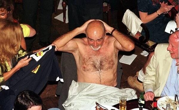 Sean Connery takes off his shirt June 1998 and puts on Scotland top given to him by his