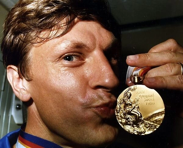 Sean Kerly kisses his 1988 Olympic gold medal at Heathrow