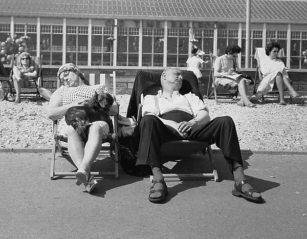 Seaside Holiday - Butlins of Bognor. A couple sleeping in their deckchairs with