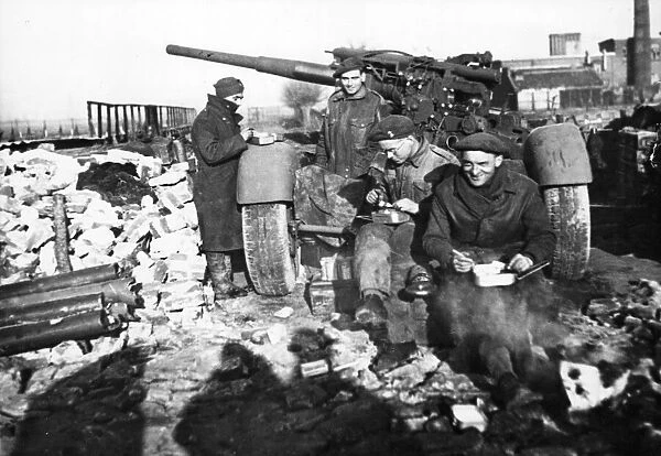 Sergeant H. Clinker of Bexleyheath, and his gun crew, eat their Christmas dinner around