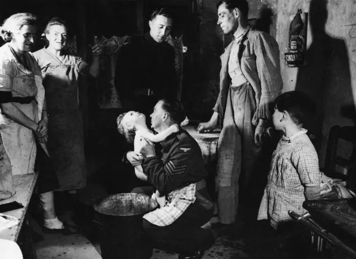 Framed Print : Sergeant Ted Okey helps a French woman bathe her child whilst Tommy Dalby talks to Framed Print : Sergeant Ted Okey helps a French woman bathe her child whilst Tommy Dalby talks to
