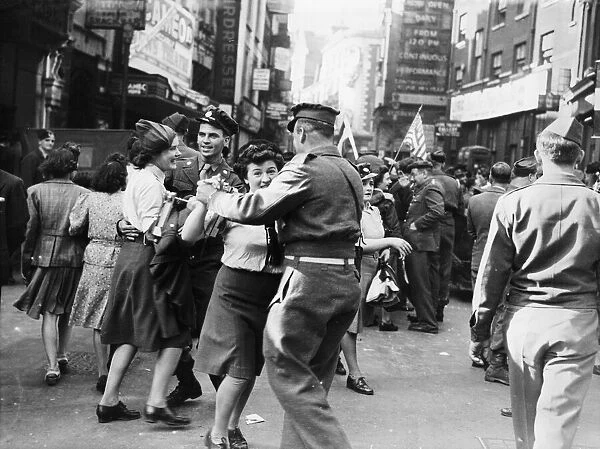 Servicemen and women dancing in the streets of London on VJ Day after Japan surrendered