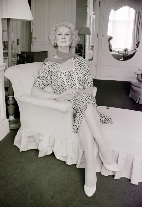 Framed Print : Sex change model April Ashley sitting on a recliner wearing a print dress hands clasped