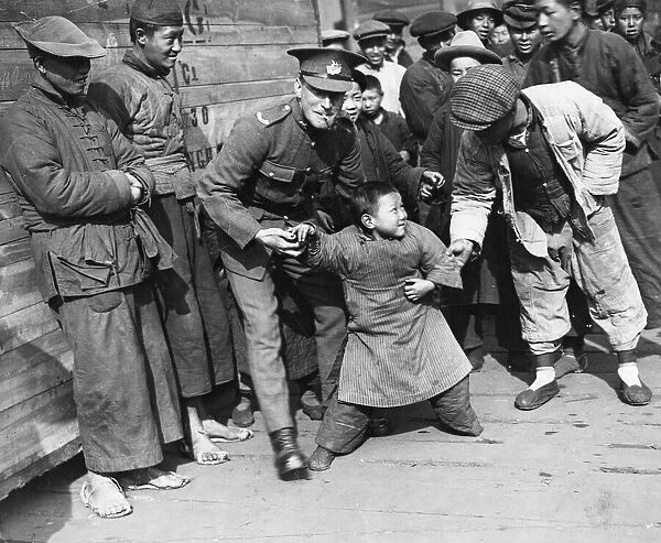Shanghai March 1927 A young chinese boy is not sure that he wants to play with
