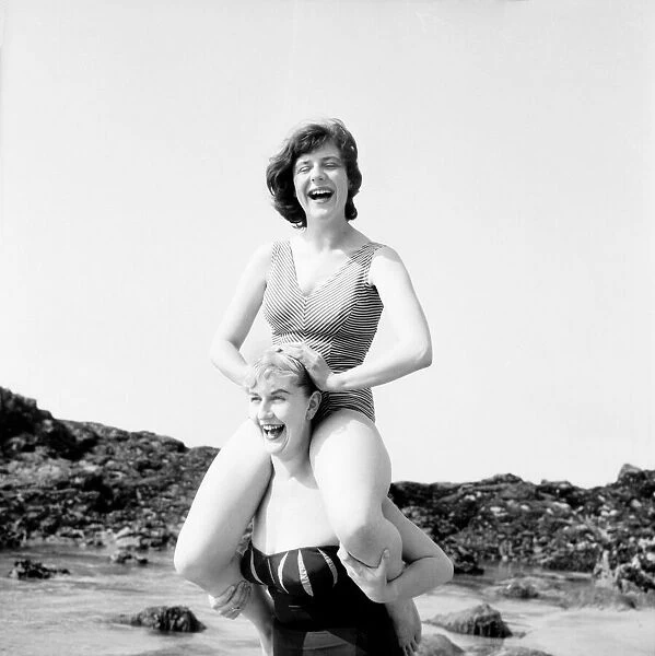 Shelagh Dawson waded into the sea carrying Wendy Shaw. June 1960 M4364-002