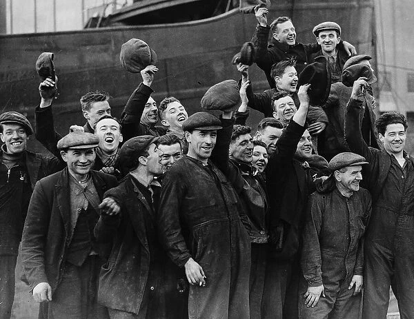 Shipyard workers celebrate holding caps in the air, cheering the King