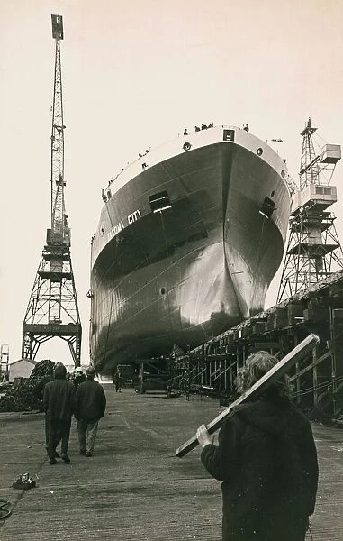 Shipyard Workers watch the launch of the Tocoma City as the new liner glides from her