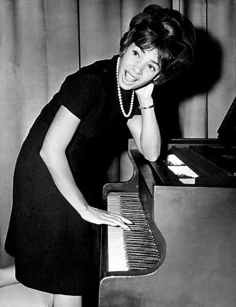 Shirley Bassey tries her hand at the piano during a press conference in the Cocktail