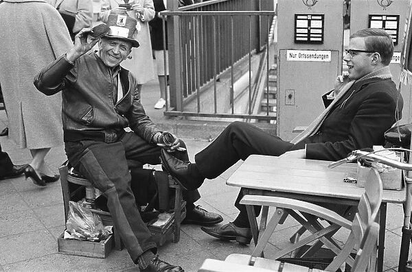 A Shoe Shine goes to work on a clients shoes close to the underground station