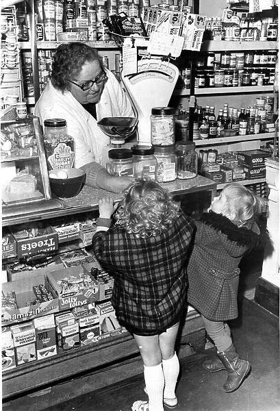 A shopkeeper serves children sweets at their local corner shop in Cardiff May 1977
