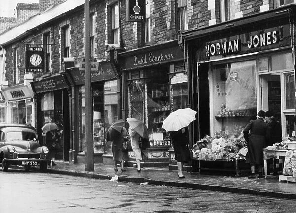Shoppers brave the November rain in Hannah Street, Porth. November 1964