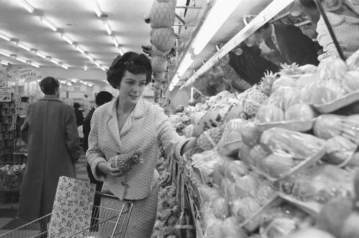 Framed Print : Shoppers browsing the fruit counter at a newly opened self service food store in North Framed Print : Shoppers browsing the fruit counter at a newly opened self service food store in North