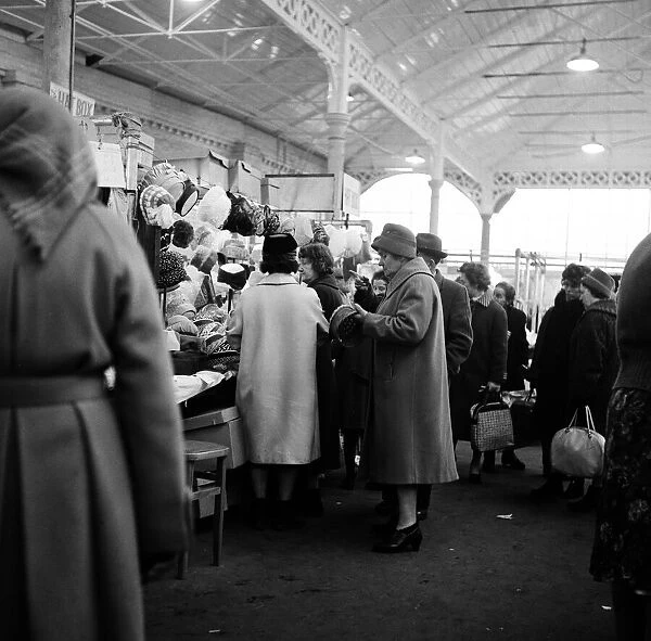 Shoppers looking at hats at Doncaster market, South Yorkshire. 5th April 1962