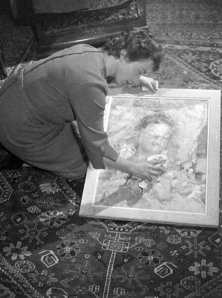 Sibylle Cole cleans a portrait she painted of her son. Glass negs taken January 1959