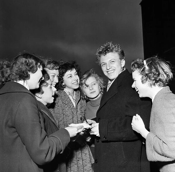 Singer and actor Tommy Steele pictured with some of his fans. 29th December 1956