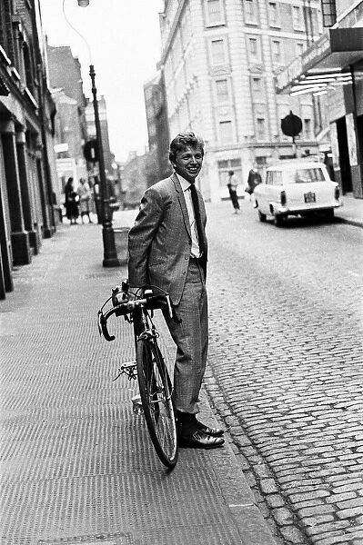 Singer and actor Tommy Steele riding his bicycle. 5th April 1963