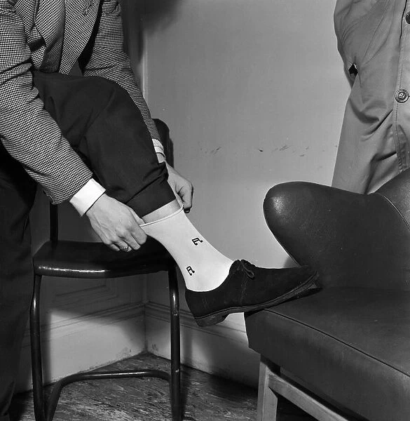 Singer and actor Tommy Steele showing off his Rock n Roll socks