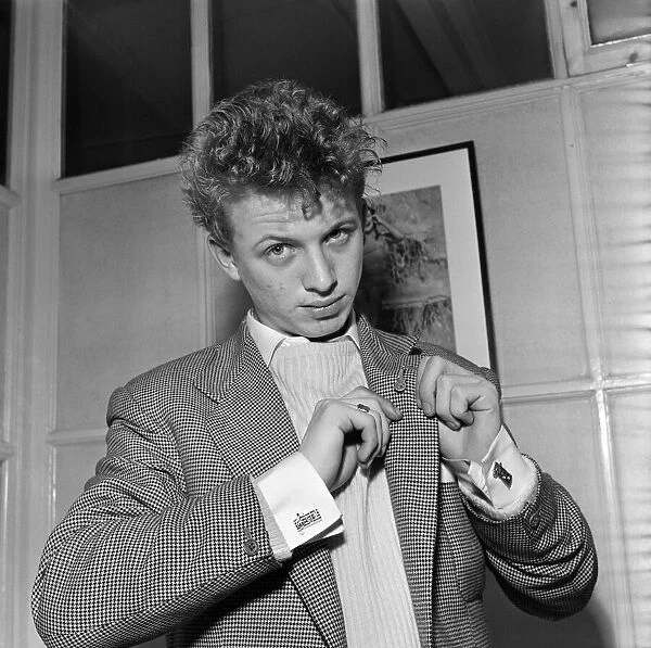 Singer and actor Tommy Steele showing of this Rock n Roll cufflinks