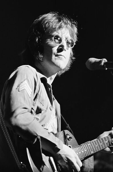 Former singer of The Beatles pop group John Lennon pictured performing on stage during